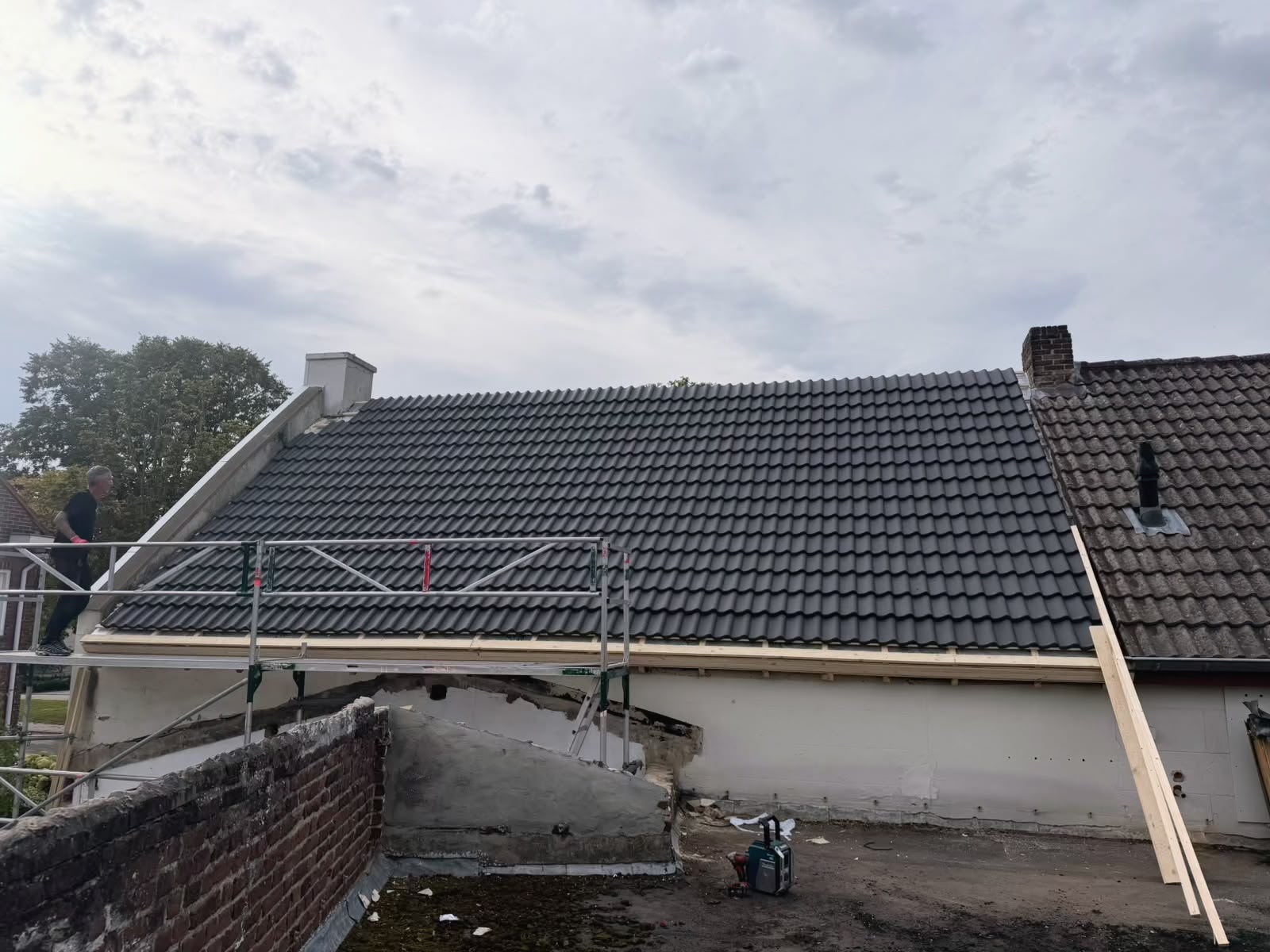 Dakpannen worden aangebracht tijdens de dakrenovatie, werkzaamheden bijna gereed