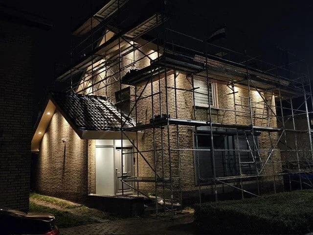 Dakproject in de avond met steiger rond de woning